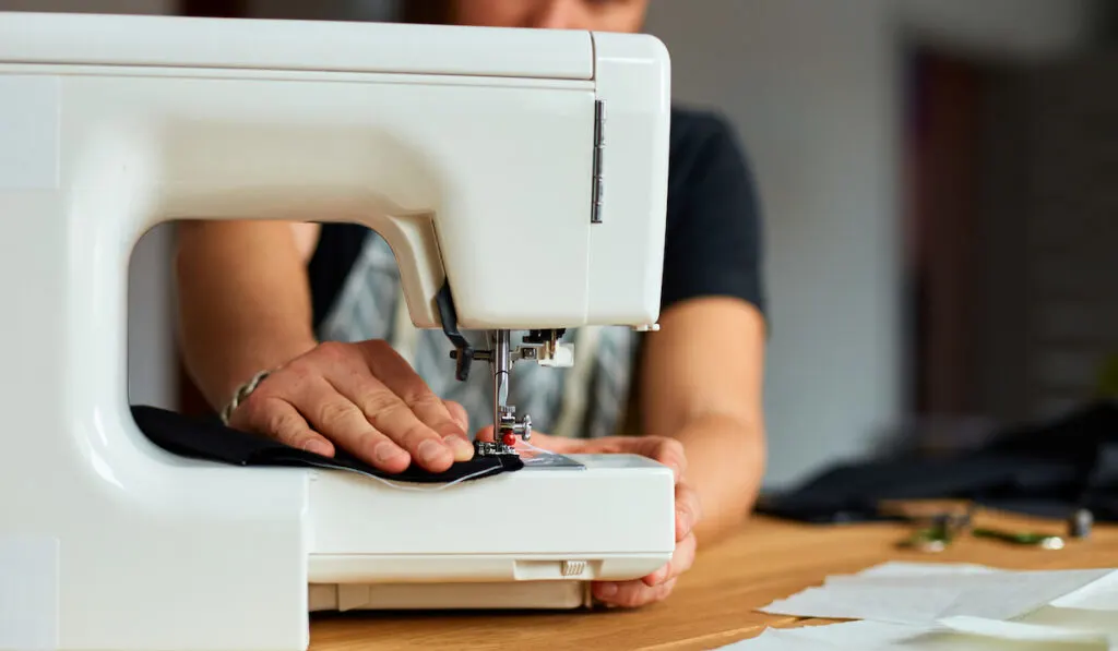 man sewing clothing