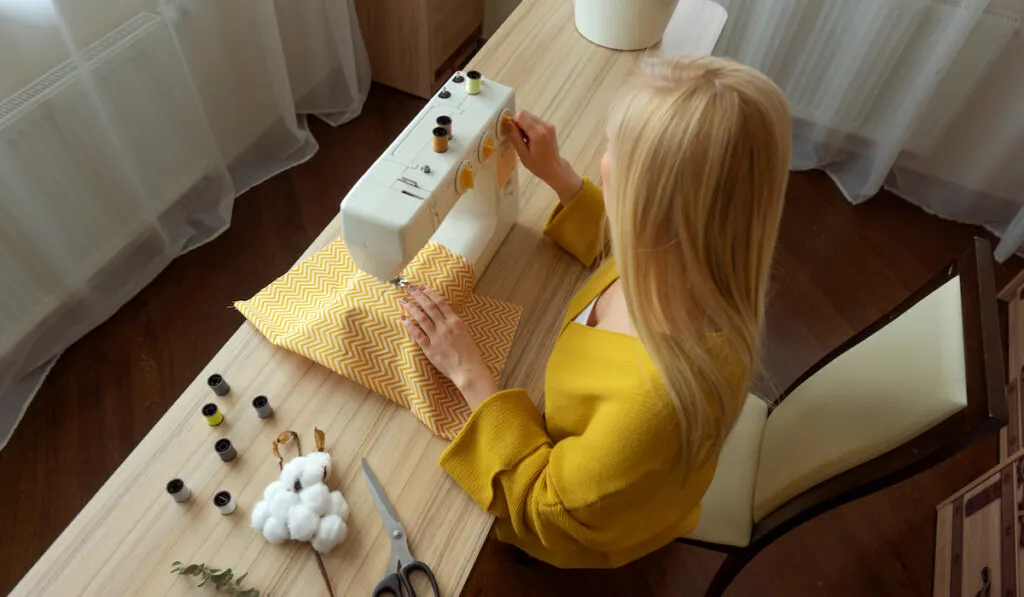 woman turning sewing machine off to rest