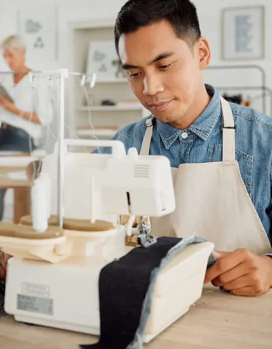 a man sewing a denim on sewing machine