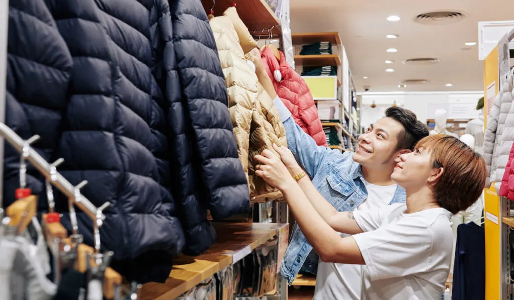 couple choosing design for winter jacket 