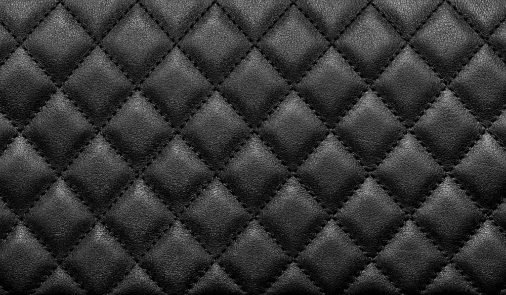 Close-up texture of genuine leather with black rhombic stitching
