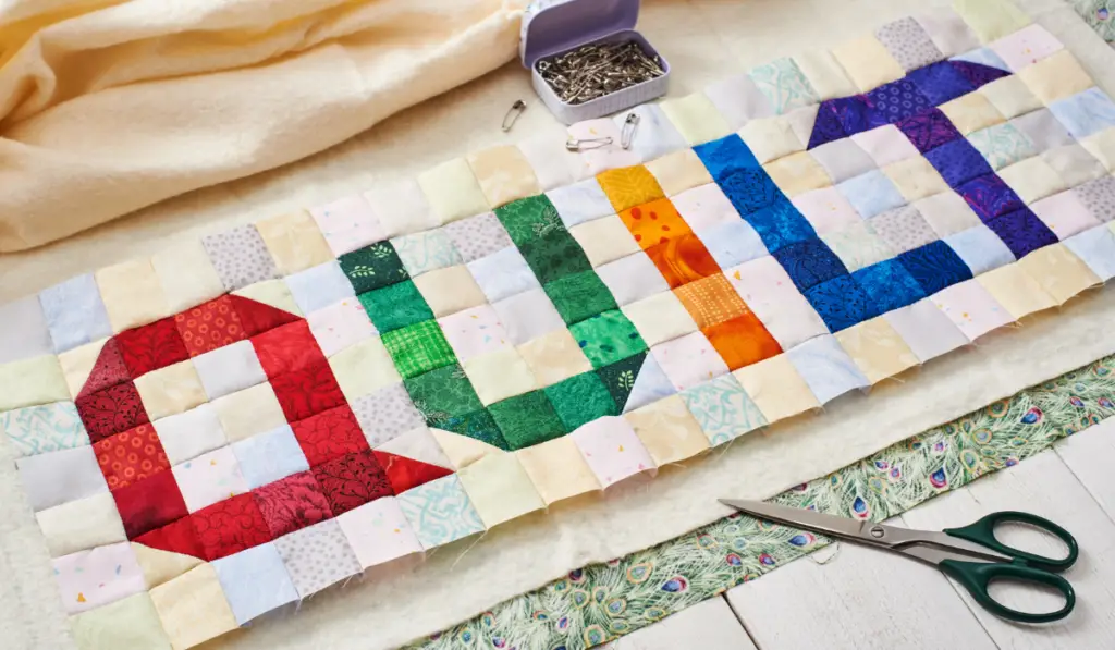 The word quilt sewn from colorful square and triangle pieces of fabric
