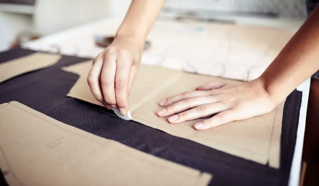 Seamstress Outlining Cardboard Pattern