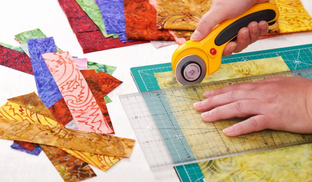 Process cutting fabric pieces by rotary cutter on mat