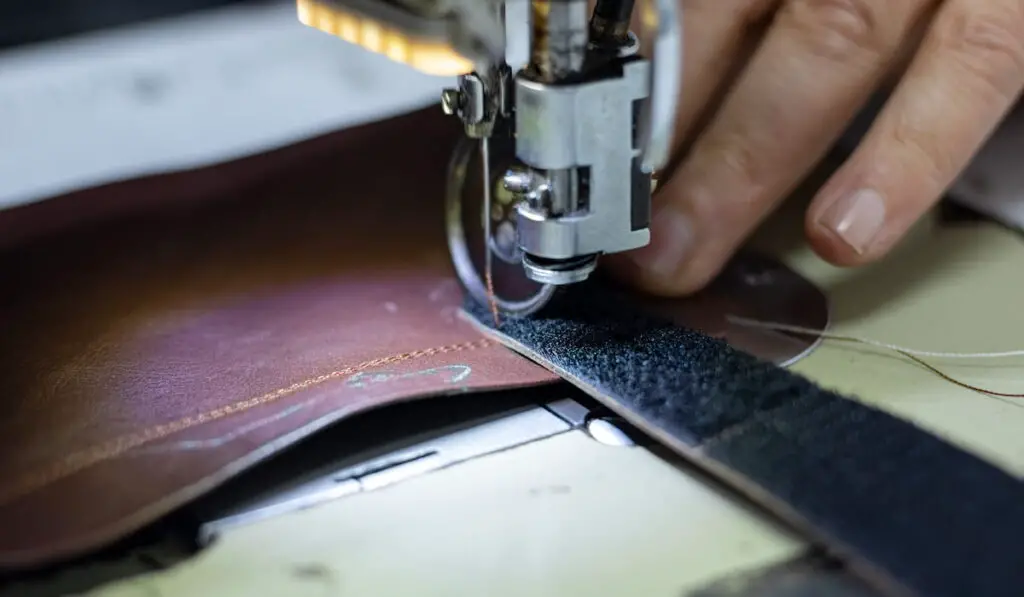 Shoemaker sewing a leather and velcro