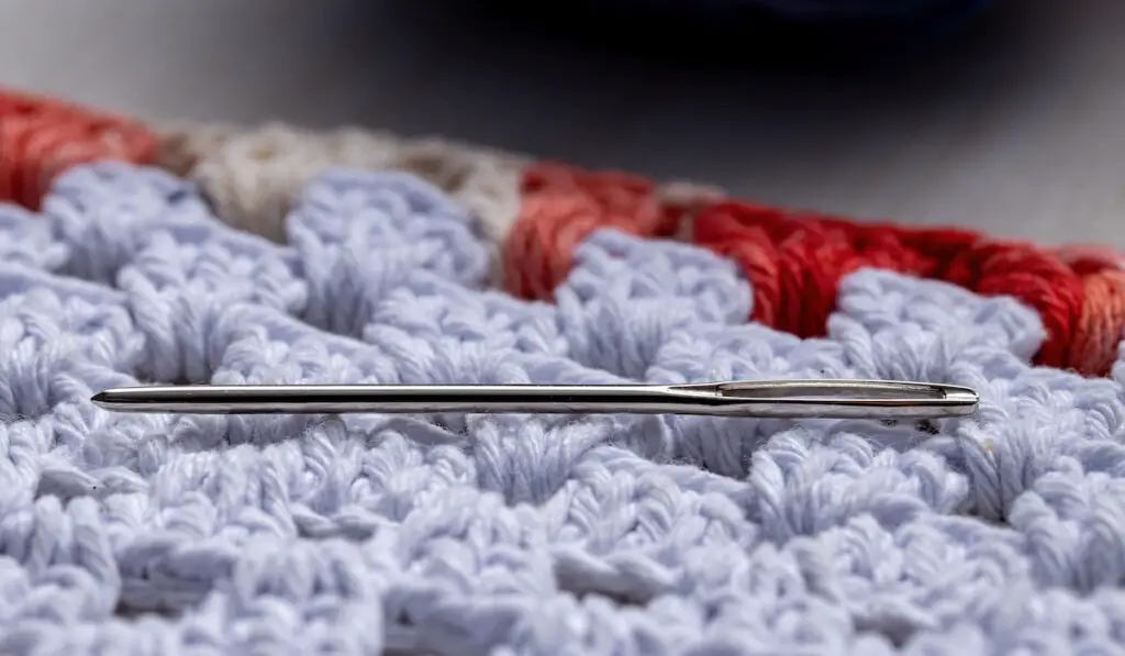 Tapestry needle against yarn product