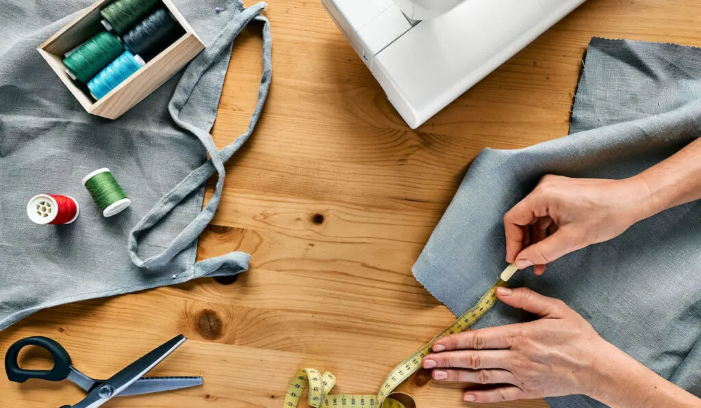 Woman taking measurements on the linen fabric 