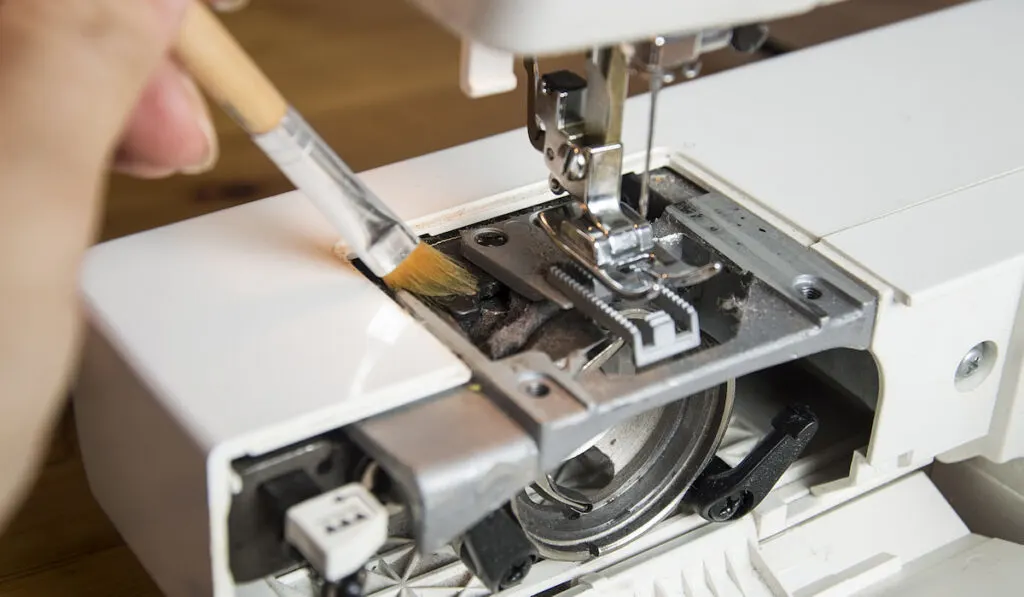 cleaning and maintenance process of a sewing machine, uses a brush to clean inside of sewing machine