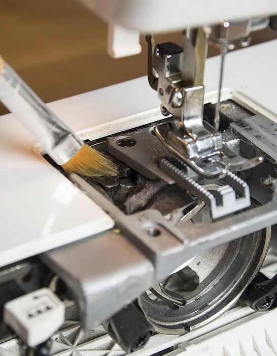 cleaning-and-maintenance-process-of-a-sewing-machine-uses-a-brush-to-clean-inside-of-sewing-machine