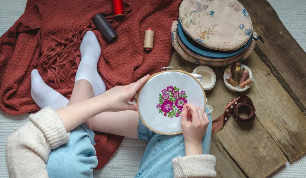 woman doing embroidery pattern flowers, handicraft hobbies