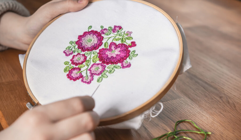 woman holding needle and Embroidery pattern flowers 
