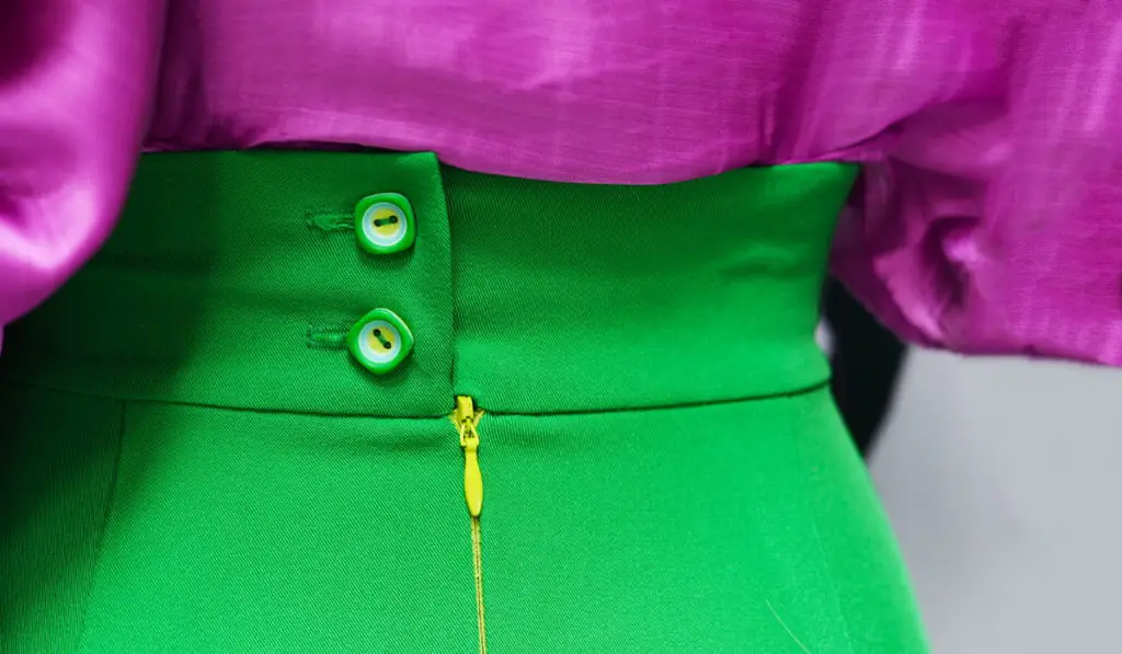 A bright green skirt with dramatic buttons and a lilac silk blouse