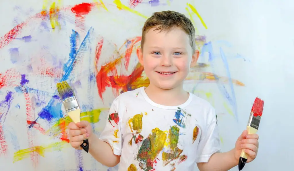 Boy in a white T-shirt, stained with paint 
