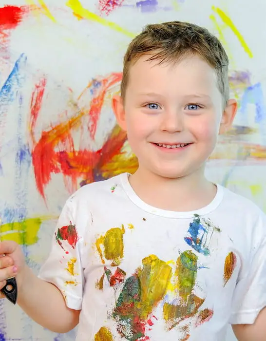 Boy in a white T-shirt, stained with paint