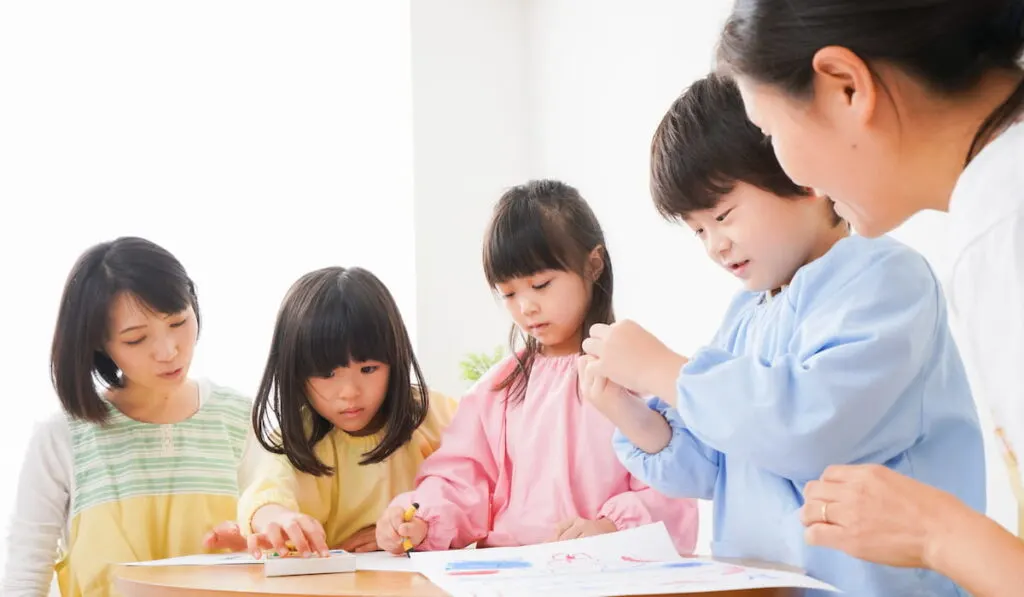 Children drawing wearing smock 