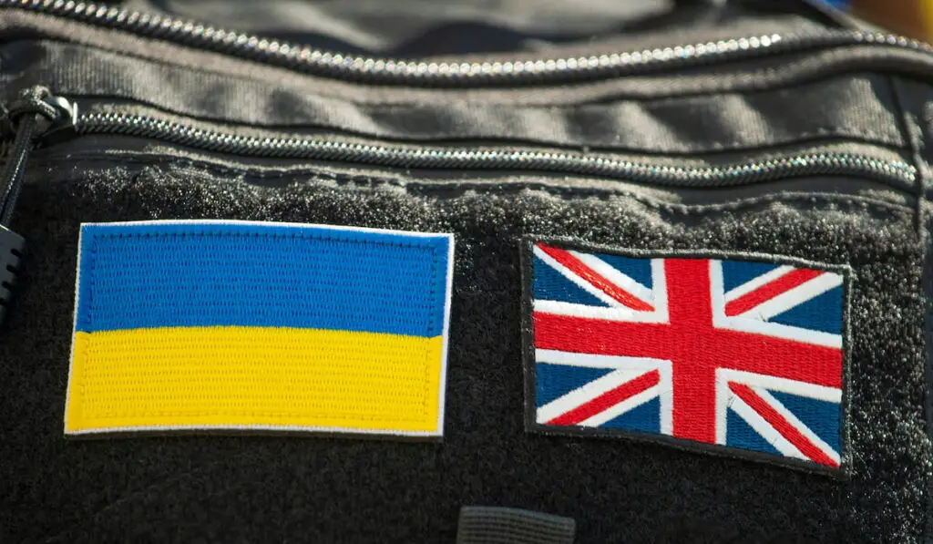 Cloth patches of the flags of the United Kingdom and Ukraine, attached side by side to the back of a black backpack