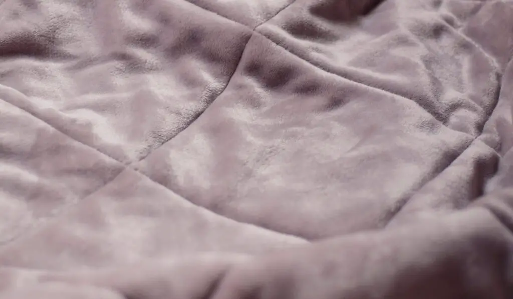 Detail of grey quilted velvet throw
