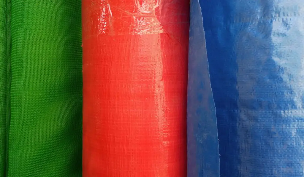 Rolls of different colored tarpaulin at a shop