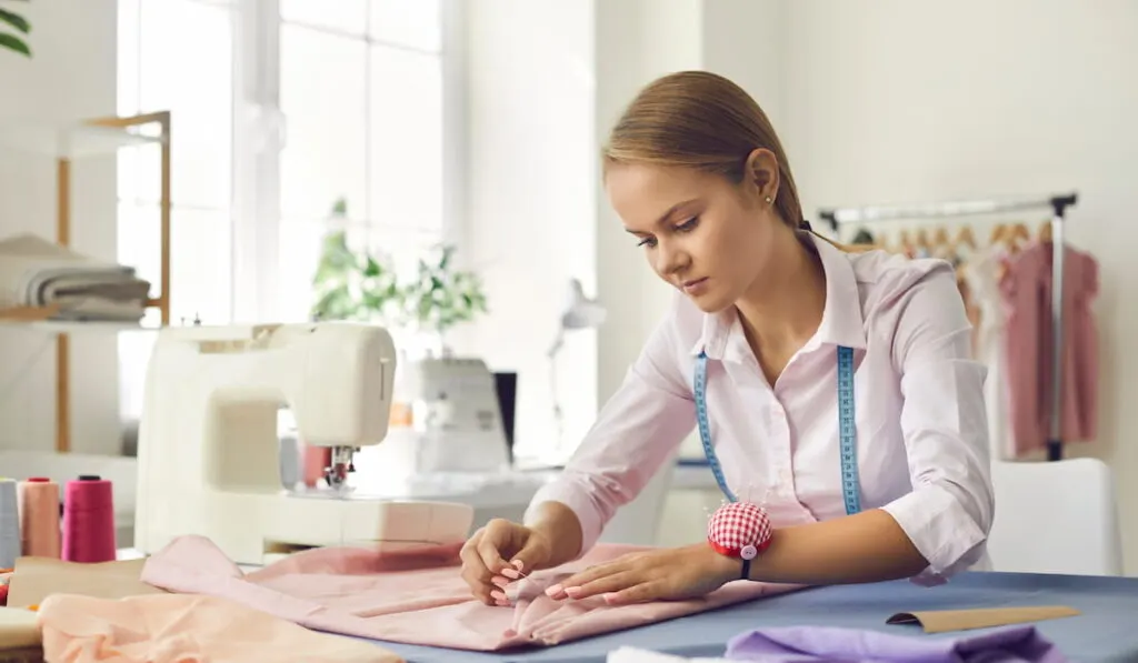 woman sews piece of fabric with her hands 