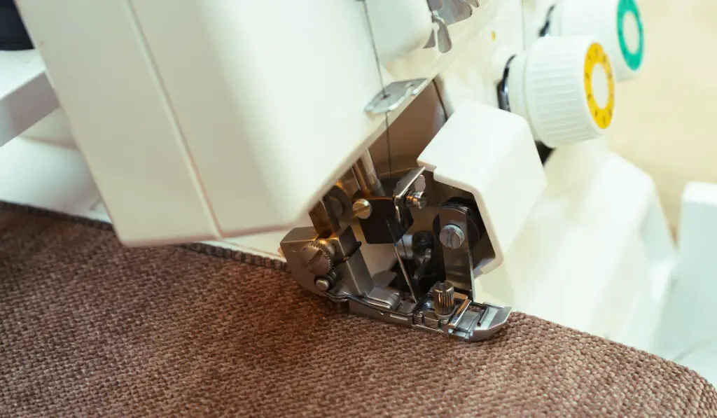 Modern overlock sewing machine pressure foot with item of clothing