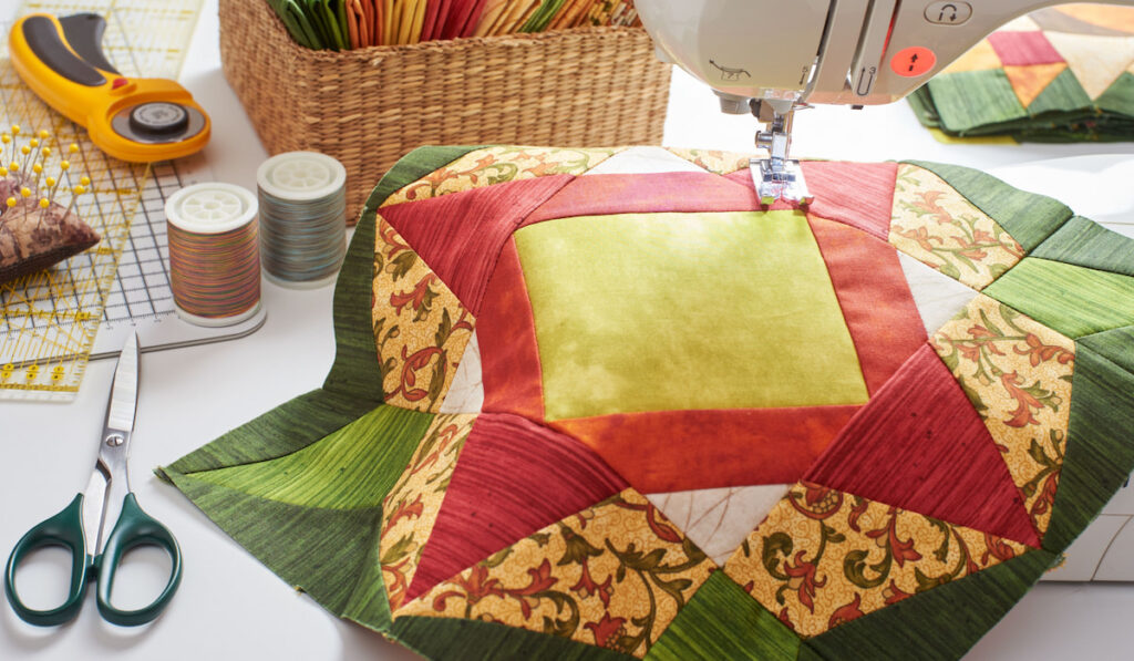 Patchwork, quilting fabrics using quilting machine and accessories on the table