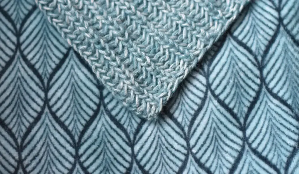 Slip stitch ribbing made of teal yarn on a blanket