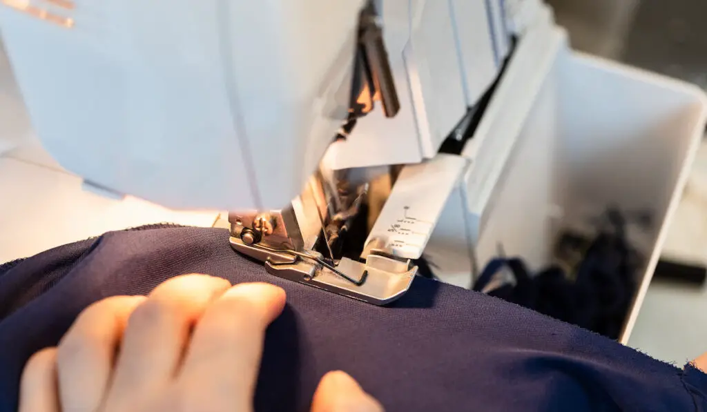 Tailor overcasting the edge of fabric on serger at home