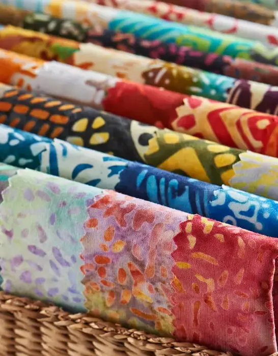 folded bright pieces of quilting batik fabrics in a basket