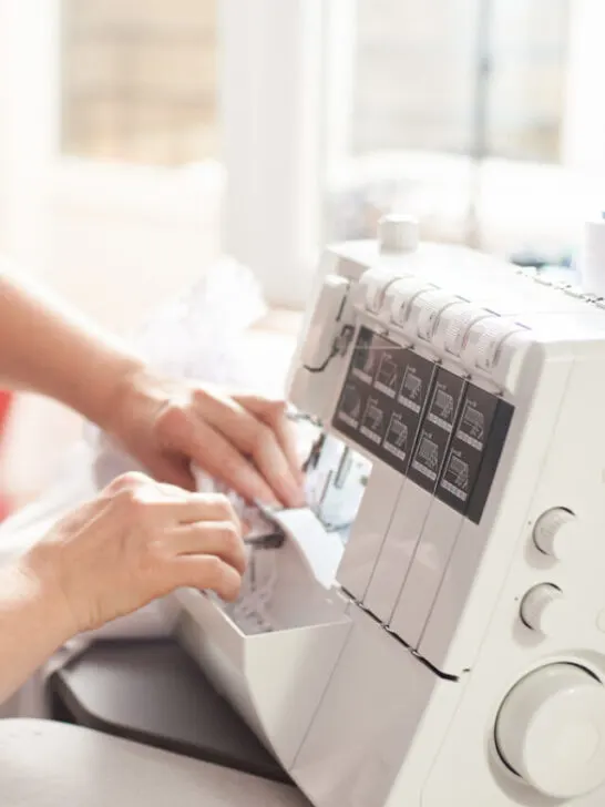 Woman in sewing studio, sewing with serger, overlocker - ee230207