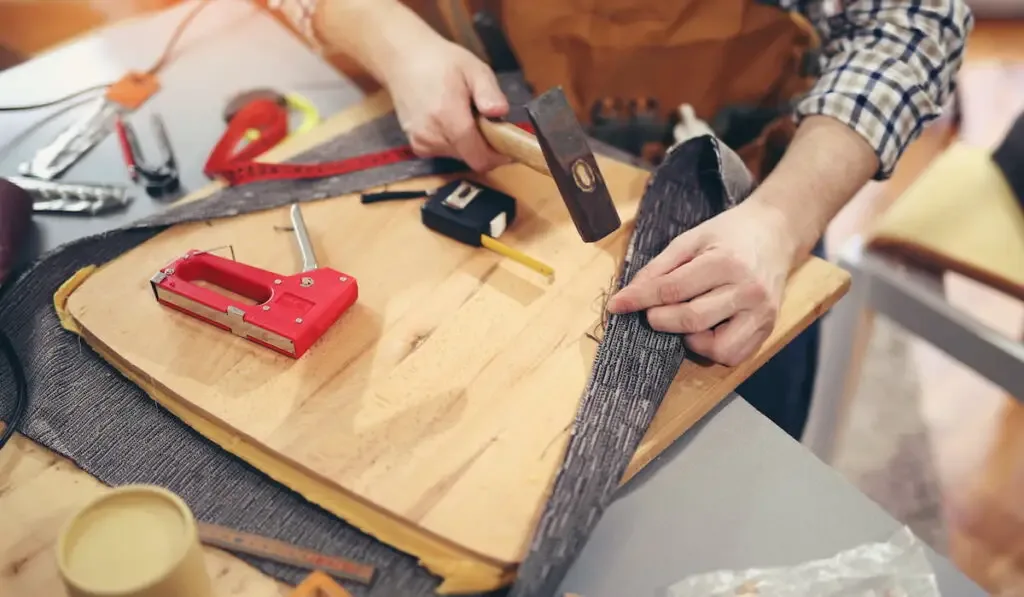 man upholstering a chair