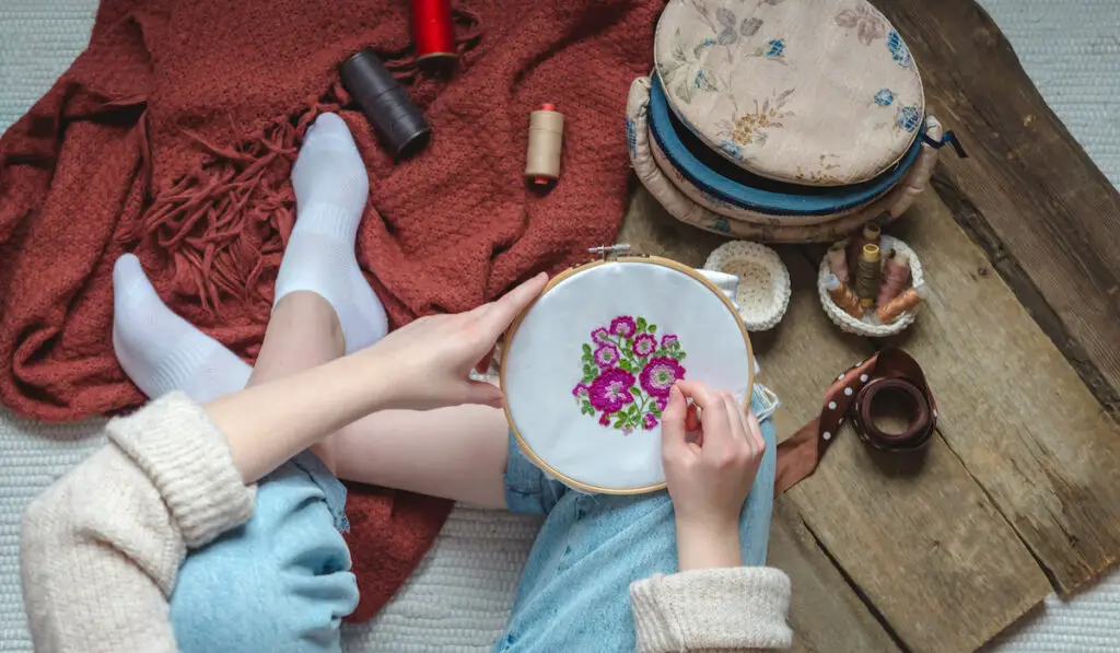 Woman finishing her embroidery flower pattern at home
