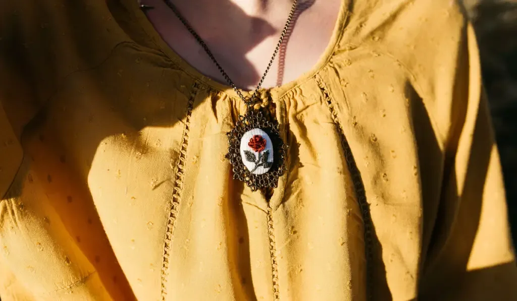 Woman in yellow dress wearing handmade embroider necklace