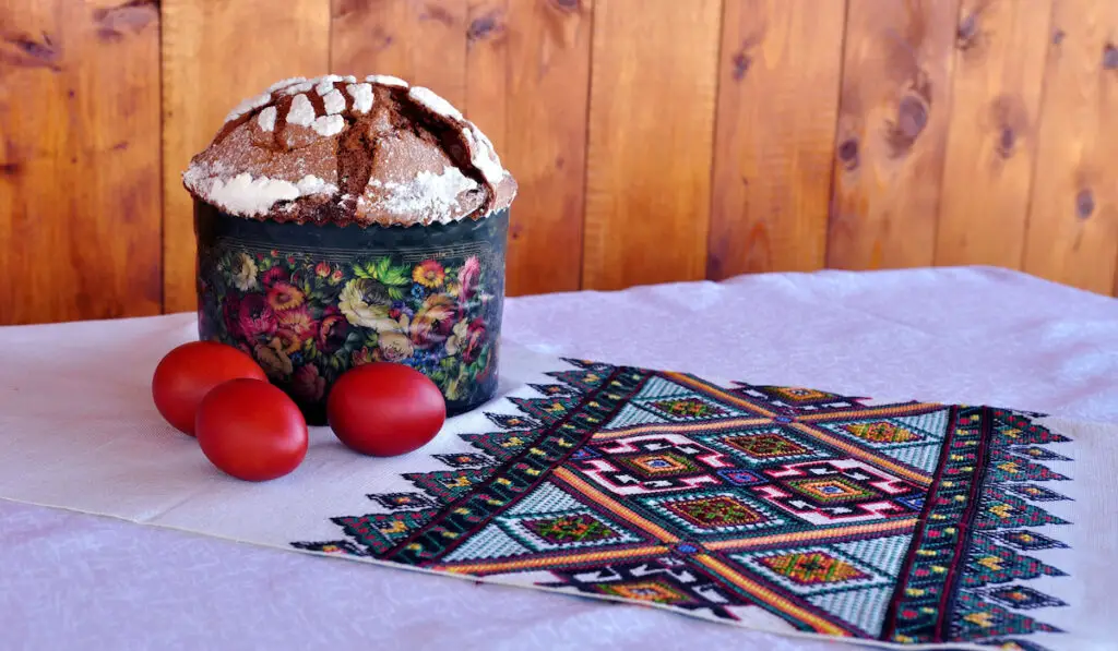 paska and painted red eggs on the table decorated with embroidered path,