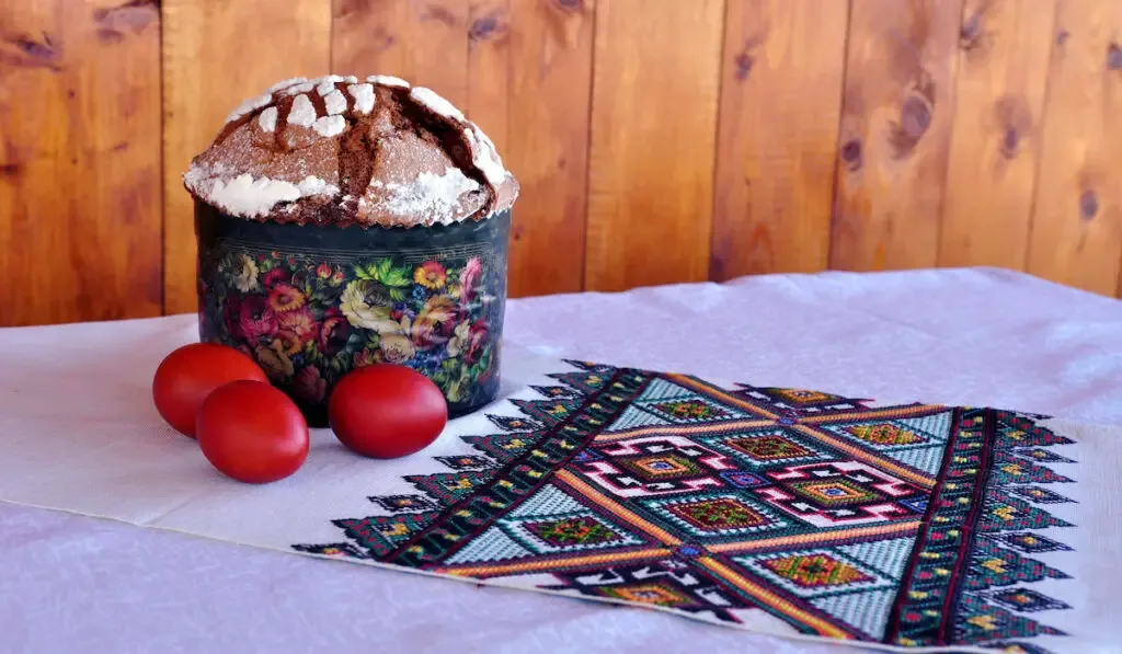paska and painted red eggs on the table decorated with embroidered path,